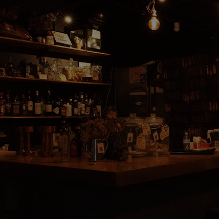 Coffee Bar Cowboysのバーカウンター。落ち着いた照明と棚に並ぶ豊富なウイスキーやリキュール