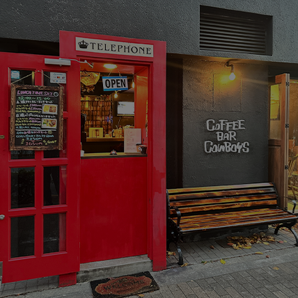 Cowboysの店舗外観。赤い電話ボックスを模した特徴的な入り口とランチメニューの看板